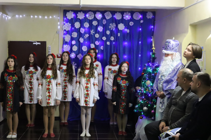 Виступ учасниць колективу "Натхнення". Праворуч сидять дорослі глядачі, стоїть ялинка, Святий Миколай.