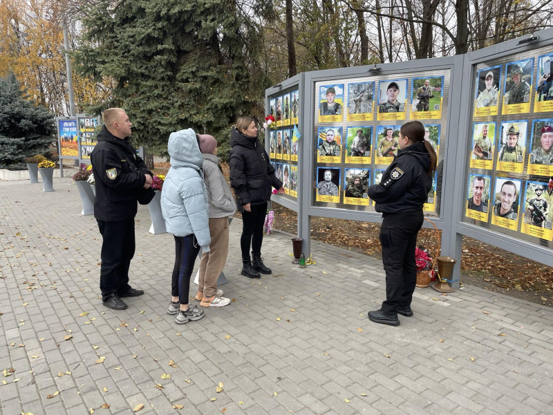 діти разом із дорослими стоять біля пам'ятної дошки загиблим воїнам