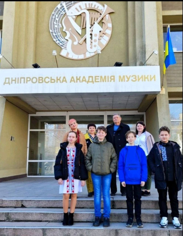 Діти разом із викладачами стоять на сходах  будівлі Дніпровської академії музики