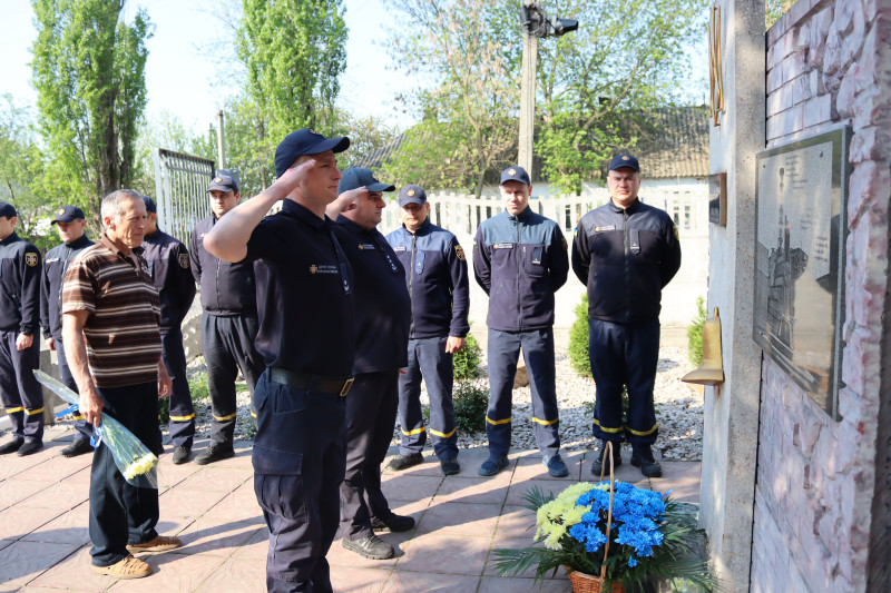 Рятувальники відідають честь загиблим чорнобильцям, поклавши квіти до підніжжя пам'ятного знаку ліквідаторам.