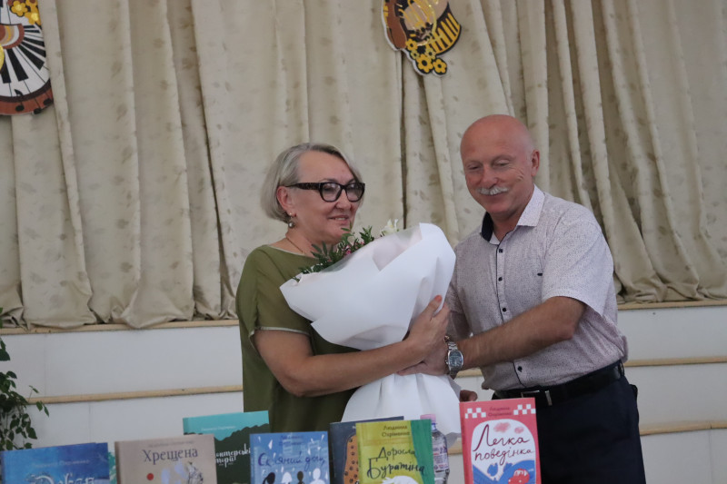 Заступник міського голови Сергій Бірюков дарує букет квітів письменниці Людмилі Охріменко 