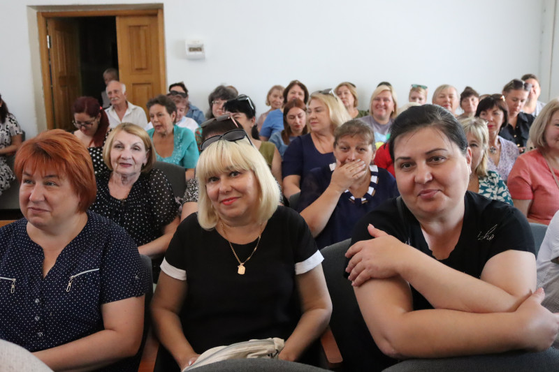 У залі сидять усміхнені жінки - відвідувачки зустрічі.  