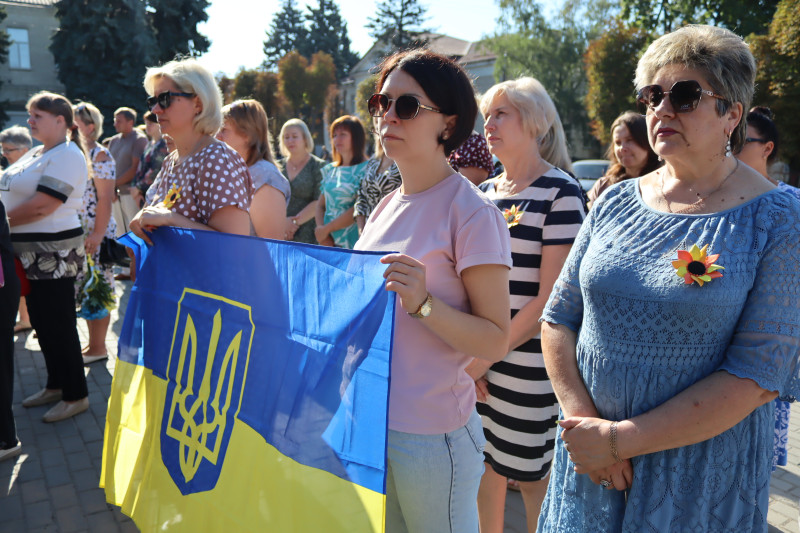 Жінки стоять на площі, тримають у руках Прапор України. На грудях - значки - символічні соняшники.