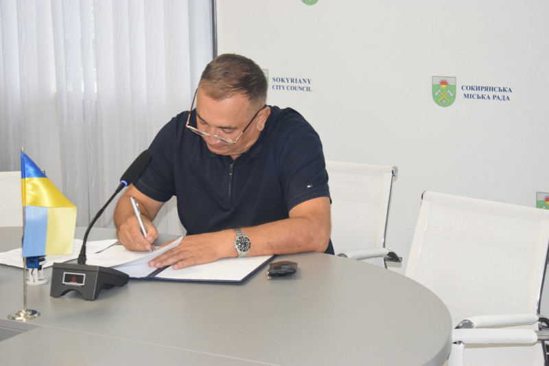 Міський голова м.Сокиряни Василь Козак підписує Меморандум про співпрацю.  