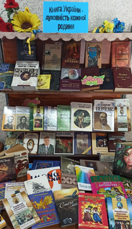 На поліці та столі - книги різних авторів, об'єднані темою: "Книга України – духовність кожної родини".