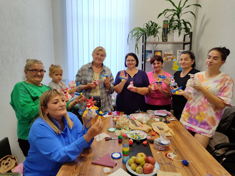 Спільне фото учасниць заходу. У кожної в руках - виготовлена лялька-мотанка та символічний янгол у синьо-жовтих кольорах.