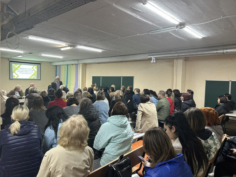 Перед батьками в укритті  виступає представник віддділу освіти міської ради. На екрані, що висить на стіні, - слайд презентації.