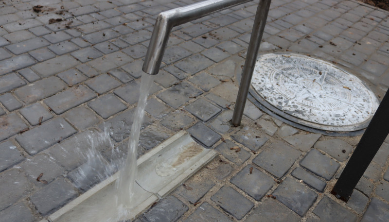 Вода тече з крану у лоток.