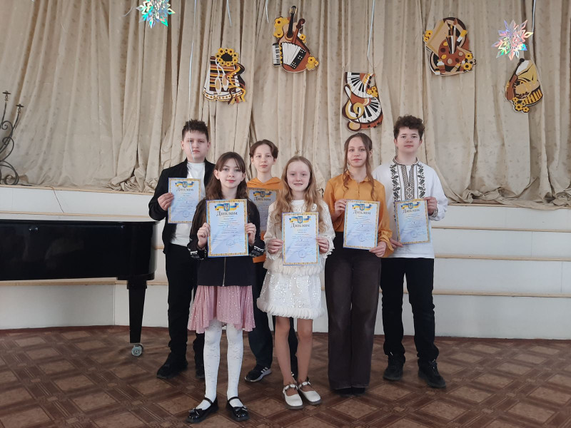 Спільне фото дітей, які тримають у руках дипломи.