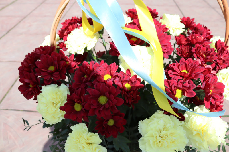 Кошик із червоно-жовтими квітами, жовто-блакитною стрічкою.