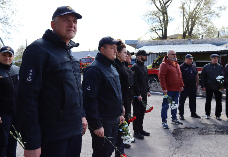 Рятувальники, правоохоронці стоять з квітами в руках.