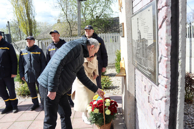Міський голова Дмитро Зражевський, начальник Синельниківської районної військової адміністрації Світлана Назарчук встановлюють  кошик із квітами до  підніжжя пам'ятного знака на честь ліквідаторів.