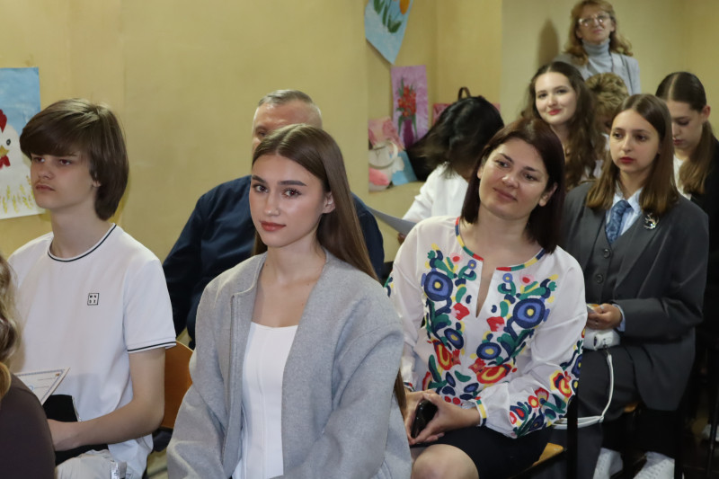 Учасники заходу: молодь, батьки, наставники сидять парами, одне за одним. 