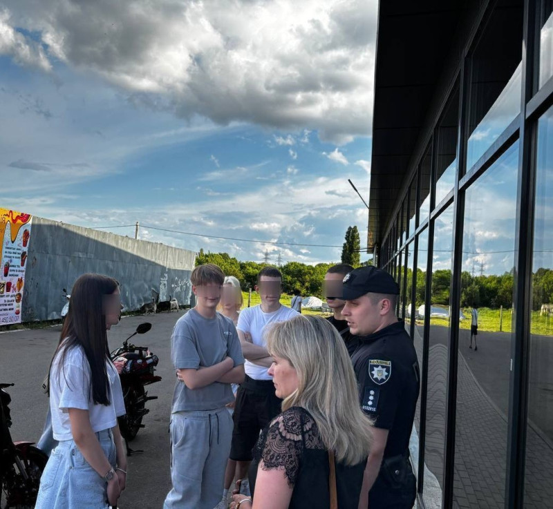 Працівники поліції і служби у справах дітей спілкуються з підлітками. За дітьми стоїть мототранспорт.
