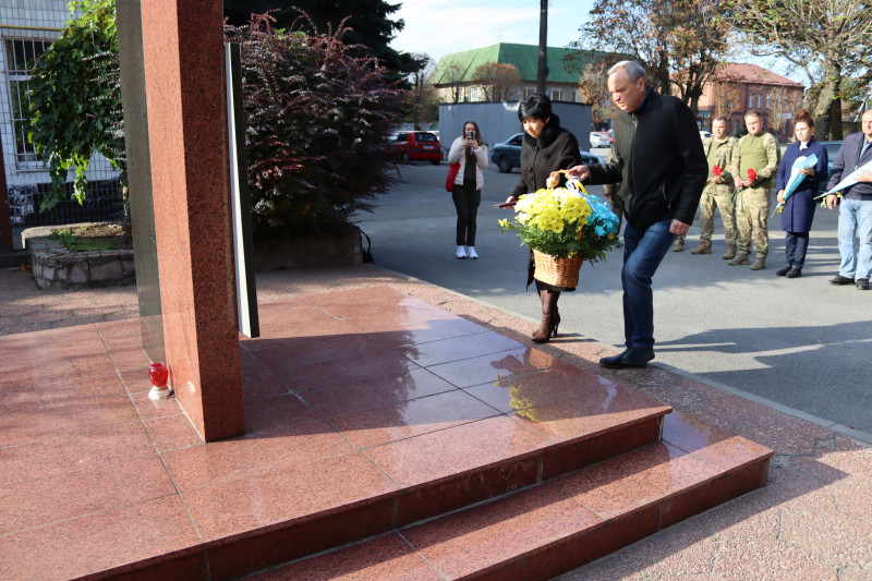 Міський голова Дмитро Зражевський та голова Синельниківської районної військової адміністрації Світлана Назарчук несуть великий плетений кошик із жовто-блакитними квітами для покладання до пам'ятного знаку загиблим Захисникам і Захисницям.
