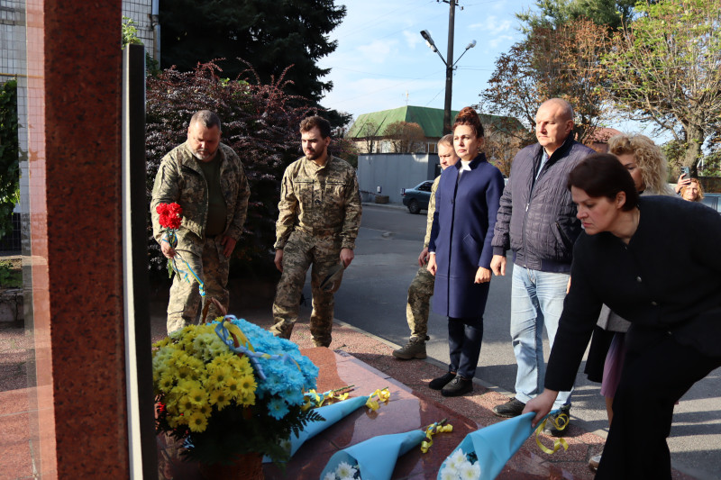 Військові та цивільні особи покладають  букети  до пам'ятного знаку загиблим Захисникам і Захисницям.